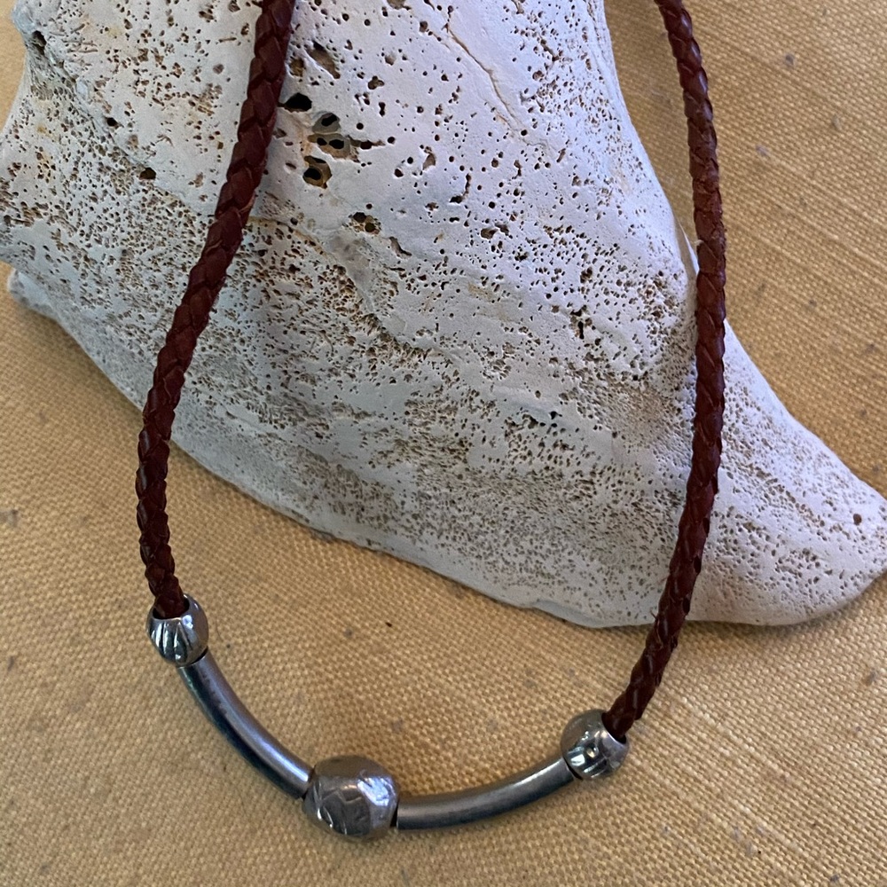 Leather braided with silver colored pieces.